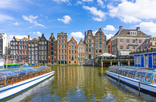 Typical canal in the center of Amsterdam. Visible are restaurants, sightseeing tourism boats at canal. Amsterdam, Netherlands.