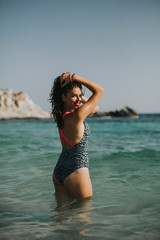 Obraz premium Young woman walking in the warm sea water at summer