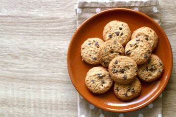 Chocolate chip cookies and polka dot napkin on wooden table. Top view.