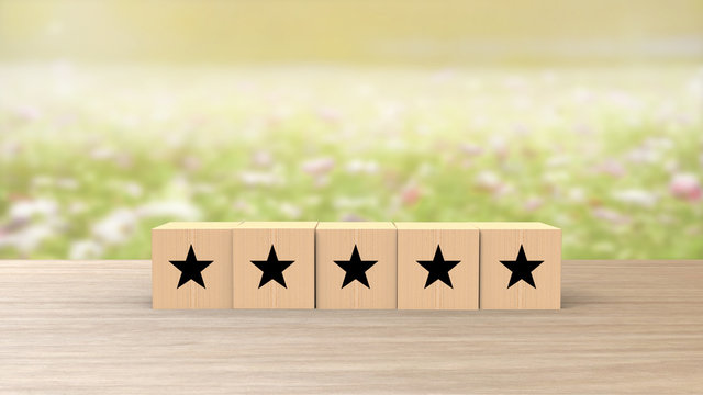 Wooden Cube Five Black Star Review On Blur Field Of Flowers Background. Service Rating, Satisfaction Concept. Reviews And Comments Google Maps, Tripadvisor, Facebook. Online Evaluations.