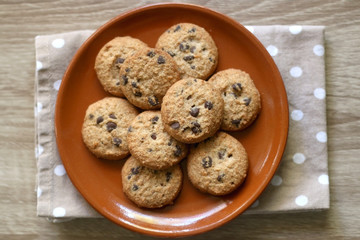 Chocolate chip cookies and polka dot napkin on wooden table. Top view.
