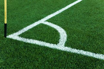 Football field corner with white marks and flag