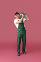 Delivery man with bottle of water on color background