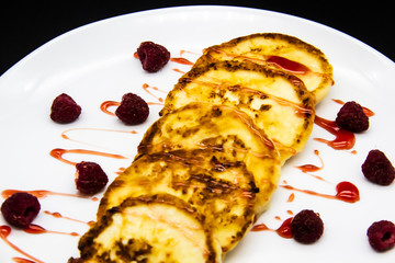 Ukrainian cottage cheese fritters, syrniki with jam on white plate. Cheese pancakes with raspberry without GMO. Delicious breakfast food at the morning.