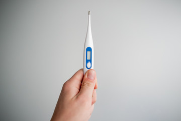 man holds a medical thermometer in his hand
