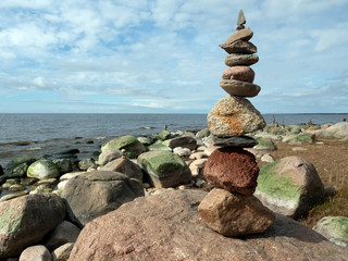 Rocky beach Baltic Sea, rocks overgrown with algae and moss, balanced piles of pebbles
