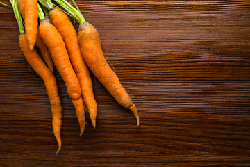 Freshly washed whole carrots on old wooden background