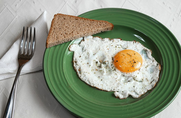 Fried eggs on a green plate with slices of bread