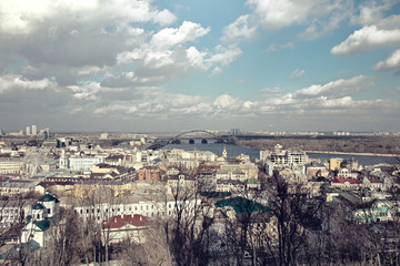 Fototapeta premium City landscape, clouds over the river in the sunlight. Ukraine, Kiev, the Dnieper River.