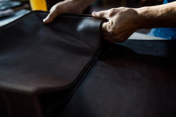 A leather craftsman works in a workshop. 