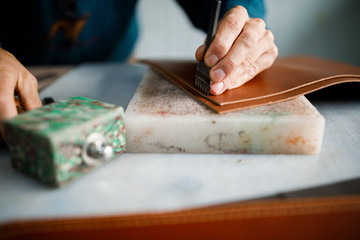Obraz premium A leather craftsman works in a workshop. 