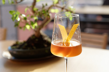 Japanese style cocktail with lemon zest in wineglass