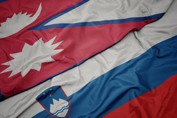 waving colorful flag of slovenia and national flag of nepal.