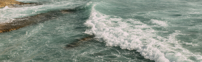 panoramic shot of white foam in blue water of mediterranean sea