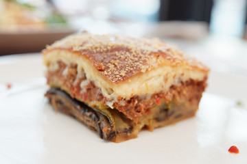 Slice of moussaka on white plate