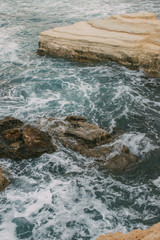 white foam near rocks in blue water of mediterranean sea