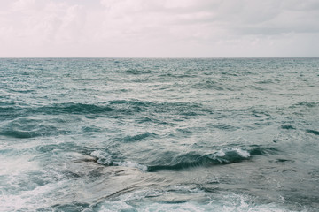 blue water of mediterranean sea against sky with clouds