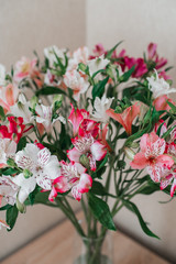 Bouquet Of Alstroemeria Flowers In Glass Vase on table. Alstroemeria flowers background. Flowers Alstroemeria.