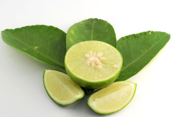 Fresh limes with green leaves on white background.