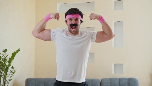 Funny retro sportsman shows biceps and looking at camera.