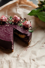 purple cake with fresh roses on a dark background