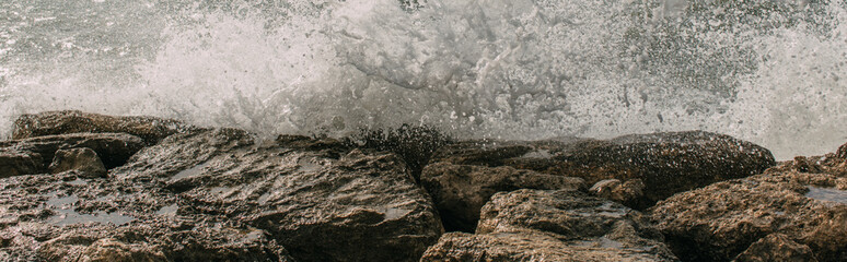 panoramic shot of wet rocks near mediterranean sea