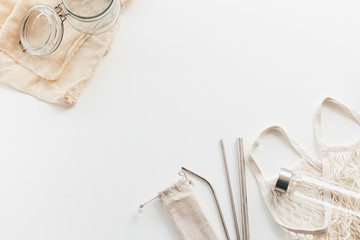 Zero waste concept. Textile eco bags, glass jars on white wooden background with copy space.