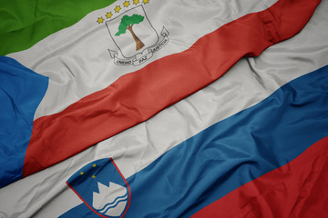 waving colorful flag of slovenia and national flag of equatorial guinea.