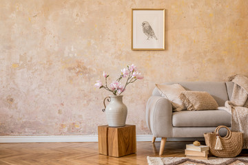 Stylish concept of living room interior with design grey sofa, mock up picture frame, dried flower,...