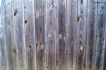 A fragment of a fence made of wooden boards with a beautiful wood texture