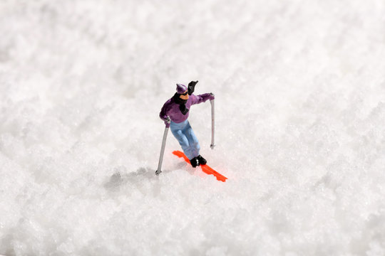 Lone Miniature Man Skiing On Fresh Winter Snow