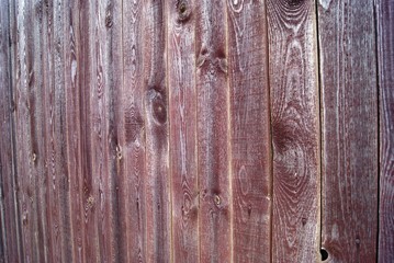 A fragment of a fence made of wooden boards with a beautiful wood texture