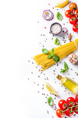 Italian food ingredients for  cooking Spaghetti Pasta. Raw spaghetti pasta with various ingredient - onion, tomatoes, garlic, basil, parsley, cheese, olive oil. On white table background, flatlay copy