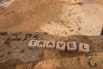wooden cubes with travel lettering on ancient ruins in cyprus