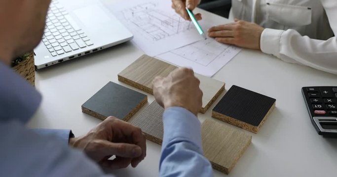 designer and customer choosing kitchen furniture materials from samples