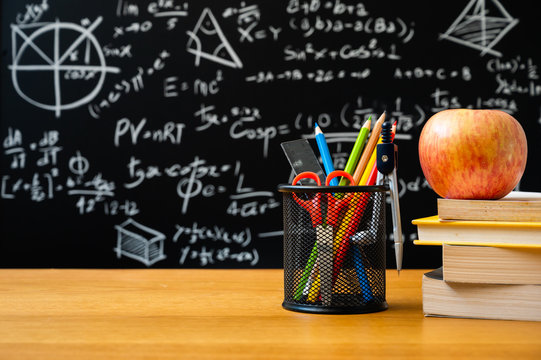 Education background concept. Stationery in holder color pencil, compasses tool, scissors, rulers, sharpener On chalkboard with the Mathematical formula background.