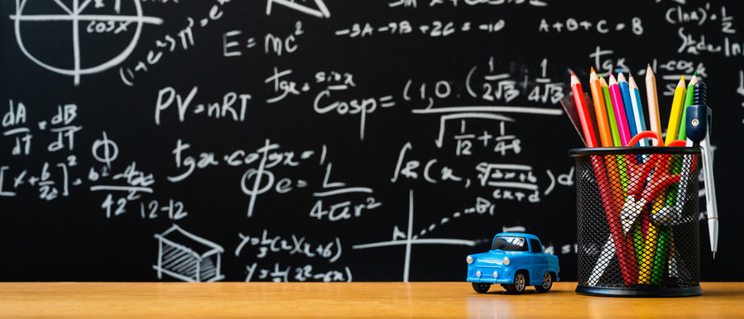 Education background concept. Stationery in holder color pencil, compasses tool, scissors, rulers, car toy On chalkboard with the Mathematical formula background.
