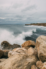 splashes of water from mediterranean sea near rocks