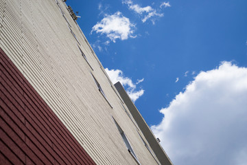 Fototapeta na wymiar Brick wall of a tall building against a blue sky