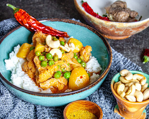 Indisches Curry-Reis-Gericht mit Erbsen und Blumenkohl dazu Samosas