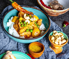 Indisches Curry-Reis-Gericht mit Erbsen und Blumenkohl dazu Samosas