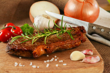 Steak medium gebraten auf Brettchen mit Zwiebeln und Rosmarien | Rumpsteak medium