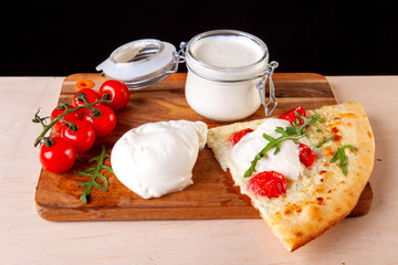 fresh pizza with ingredients in it on a wooden board