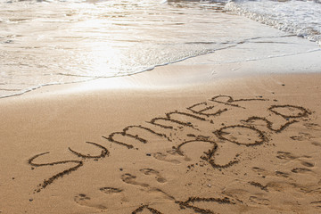 beach with summer 2020 lettering on sand near sea