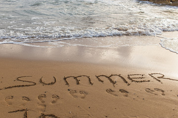 beach with summer lettering on sand near sea