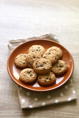Chocolate chip cookies and polka dot napkin on wooden table. Selective focus.