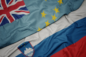 waving colorful flag of slovenia and national flag of Tuvalu .