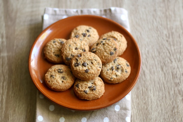 Chocolate chip cookies and polka dot napkin on wooden table. Selective focus.
