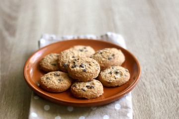 Chocolate chip cookies and polka dot napkin on wooden table. Selective focus.