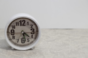 the white table clock stands and shows the time, the mode is necessary for everyone, including the...